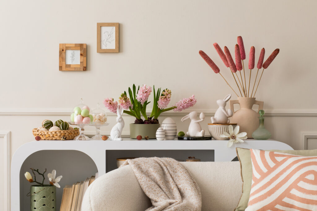 Interior design of easter living room interior with mock up poster frame, stylish white sideboard, hyacinth, easter bunny, vase with dried flowers and personal accessories. Home decor. Template. Interior design of easter living room interior with mock up poster frame, stylish white sideboard, hyacinth, easter bunny, vase with dried flowers and personal accessories. Home decor
